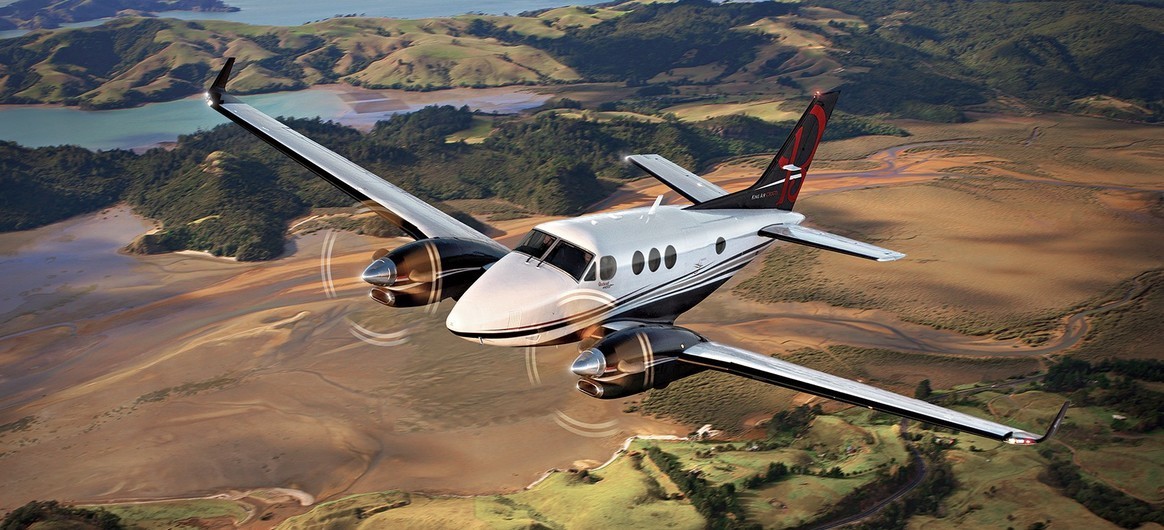 King Air C90GTx flying over fields