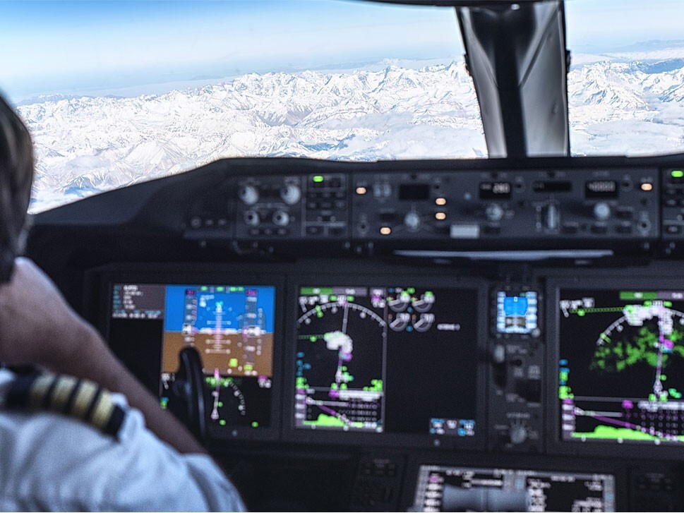 Private jet cockpit with snow-covered mountains outside window