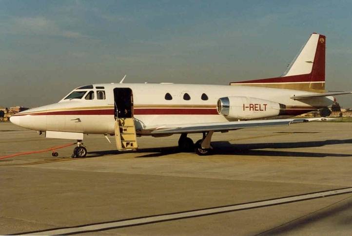 1974 sabreliner 40 parked on sunny airfield side view of aircraft paintwork white with maroon and gold stripes
